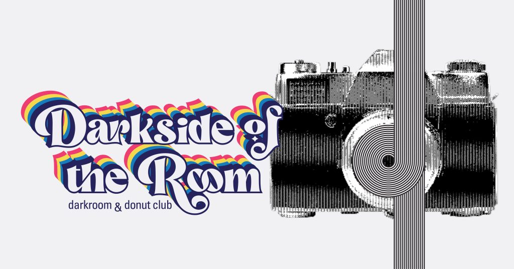 A 70s-inspired font with rainbow shadows reads “Darkside of the Room: darkroom and donut club”. To the right, a halftone image of a SLR camera with black and white geometric lines curving around lens.